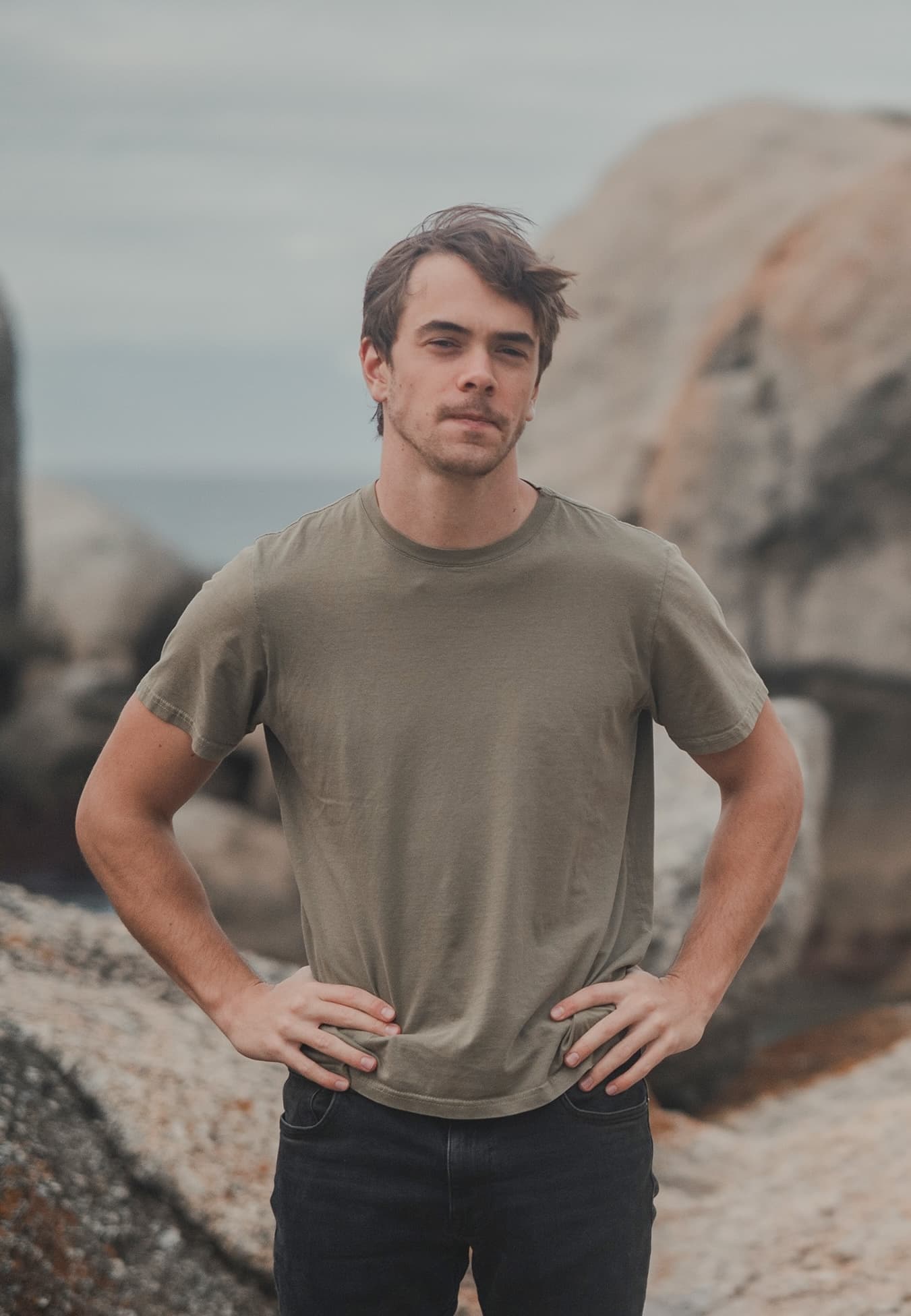 Matt Derman standing between coastal rocks